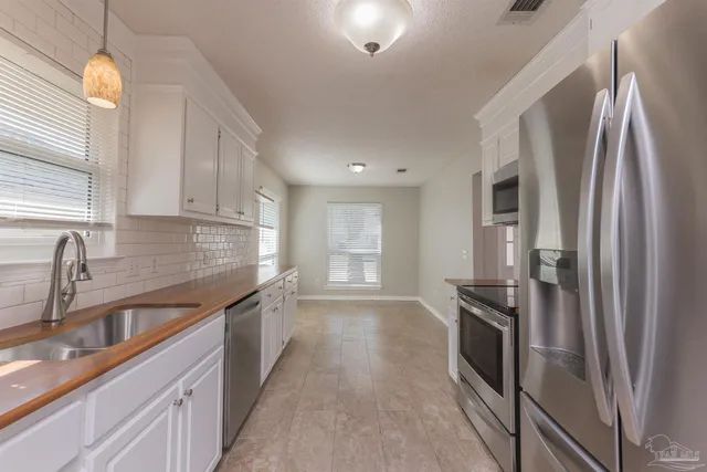 a kitchen with stainless steel appliances granite countertop a refrigerator and a sink