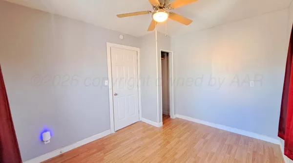 a view of empty room with wooden floor