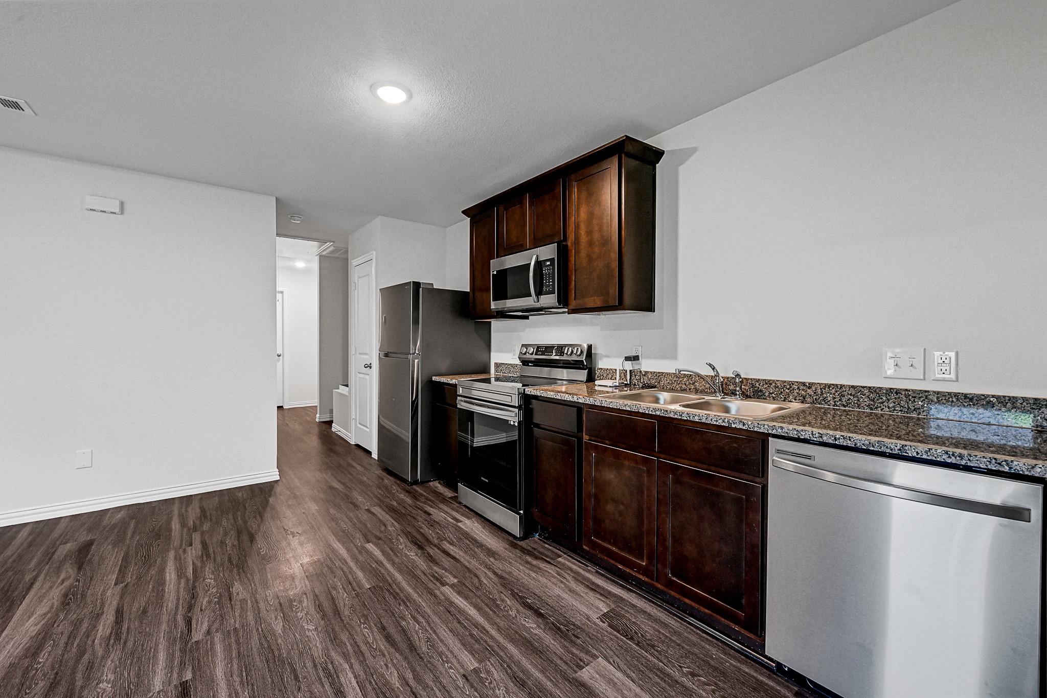 a kitchen with granite countertop a stove top oven and sink