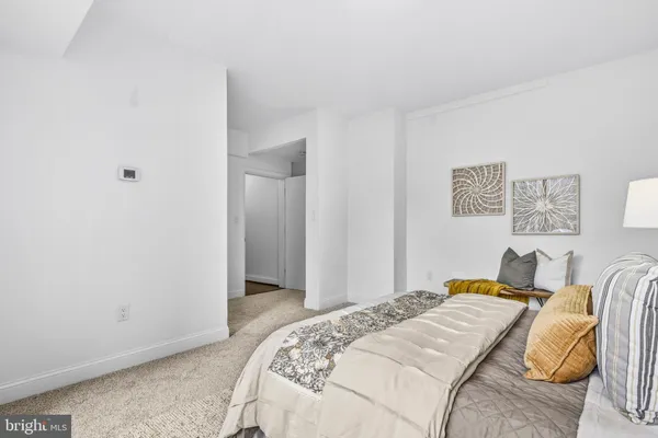 a bedroom with a bed and painting on the wall