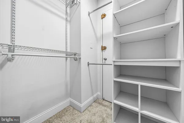 a view of walk in closet with empty racks