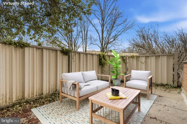 a view of a patio with couches and a table and chairs with wooden fence