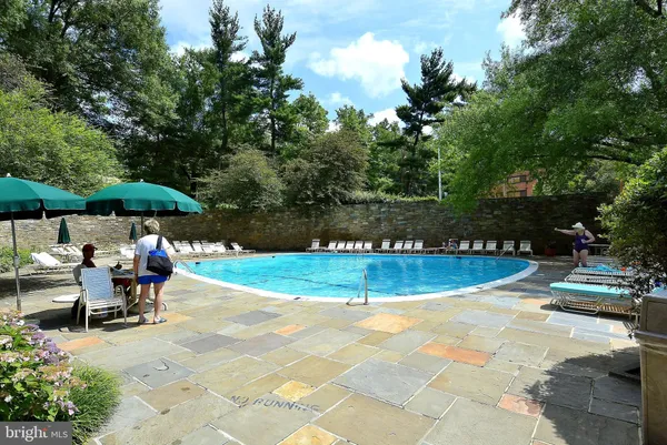 a view of a swimming pool with sitting area and furniture