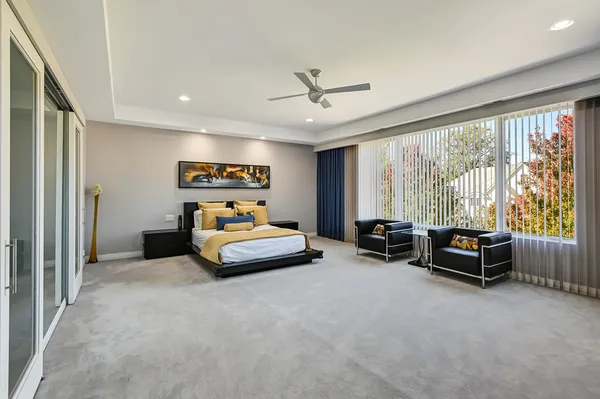 a bedroom with furniture and a large window