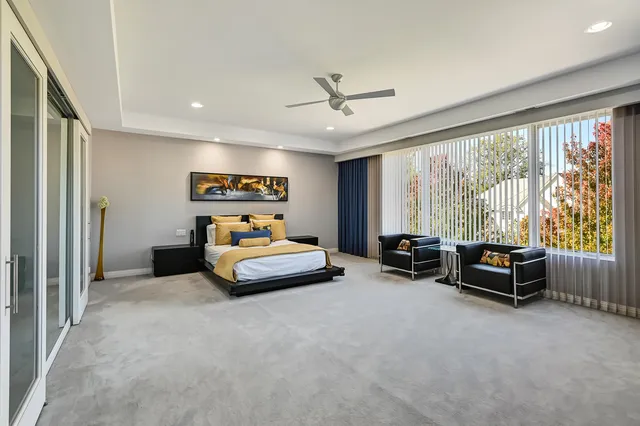 a bedroom with furniture and a large window