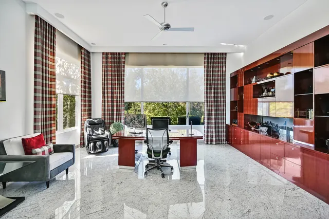 a living room with patio furniture and a large window