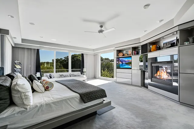 a spacious bedroom with a bed and glass window