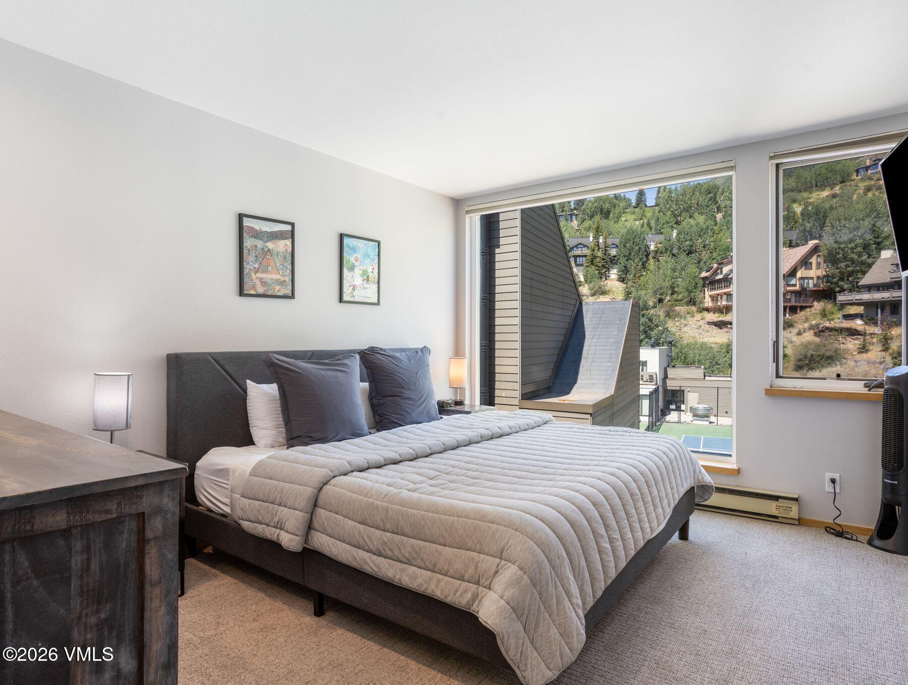 1100 North Frontage Road West, Unit 1503 Vail, CO 81657 - Photo 6 of 32 a bedroom with a large bed and a large window