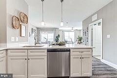 406 Bold Ruler Court, Unit 204 Havre de Grace, MD 21078 - Photo 5 of 34 a kitchen with kitchen island white cabinets and white appliances