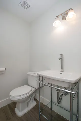 a bathroom with a toilet a sink and mirror