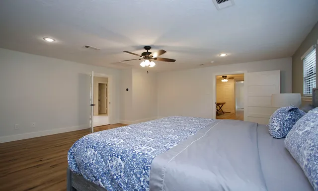 a bedroom with a large bed and a chandelier