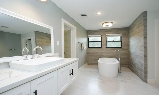 a spacious bathroom with a double vanity sink a mirror and a toilet