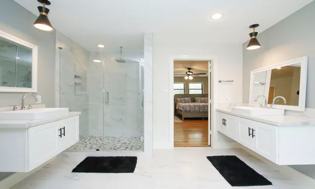 a en suite bathroom with a double vanity sink a mirror and a shower