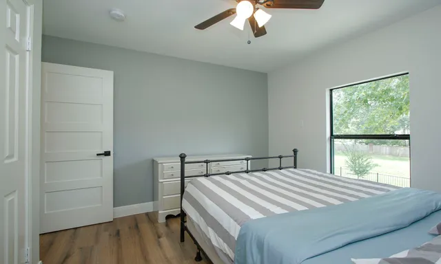 a bedroom with a bed and a large window