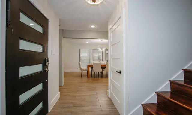 a hallway with dining room and chandelier