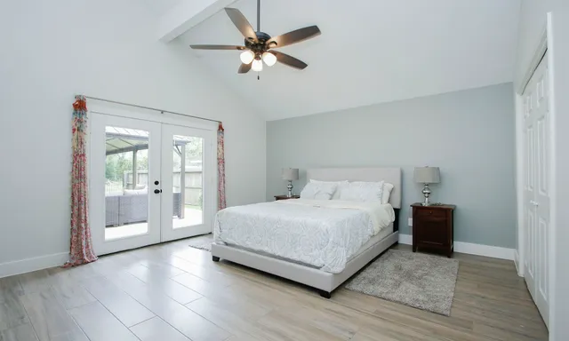a spacious bedroom with a bed and a chandelier