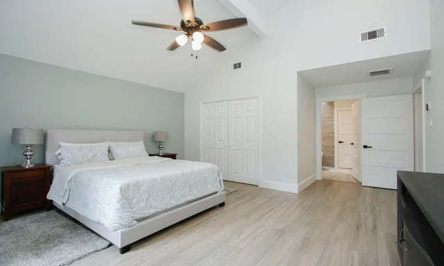 a bedroom with a bed and a ceiling fan