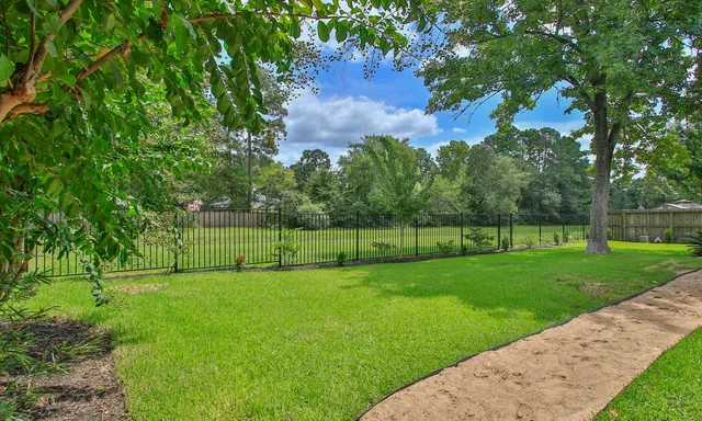 a view of a yard with a fence and trees