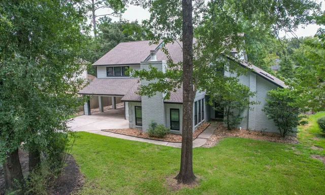 a front view of a house with a yard and trees