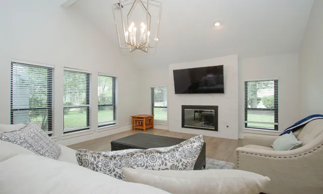 a living room with furniture a fireplace and a flat screen tv