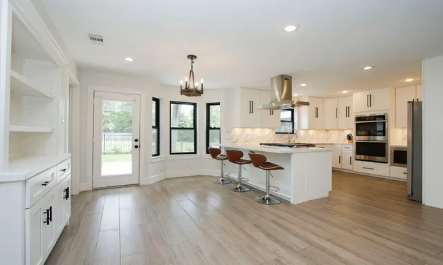 a living room with stainless steel appliances kitchen island hardwood floor and wooden floor