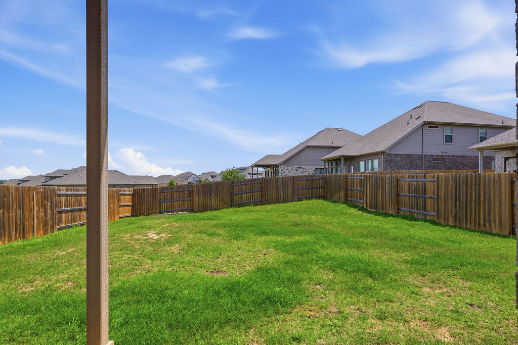 1005 Ridge Runner Drive Georgetown, TX 78628 - Photo 31 of 32 Expansive backyard featuring a lush green lawn, full perimeter wood fencing, and a covered patio structure
