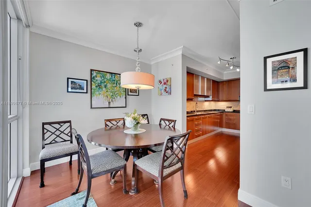 a view of a dining room with furniture a chandelier and wooden floor