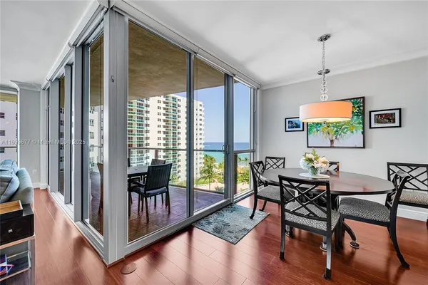 a kitchen with stainless steel appliances granite countertop wooden cabinets a dining table and chairs