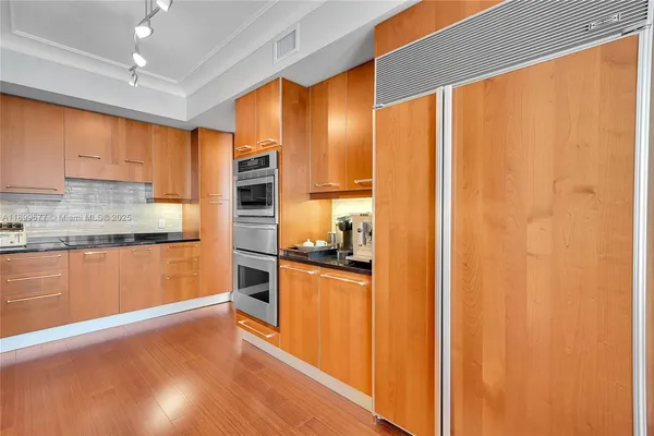 a kitchen with stainless steel appliances a refrigerator and a stove top oven