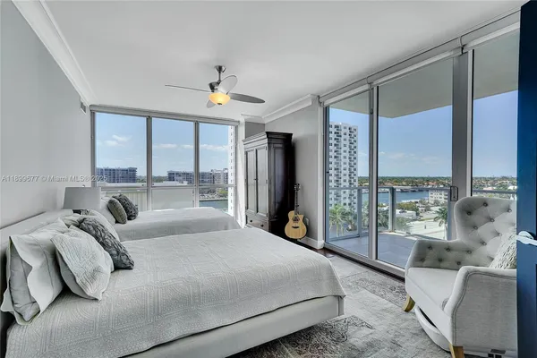 a bedroom with a large bed and a chandelier fan