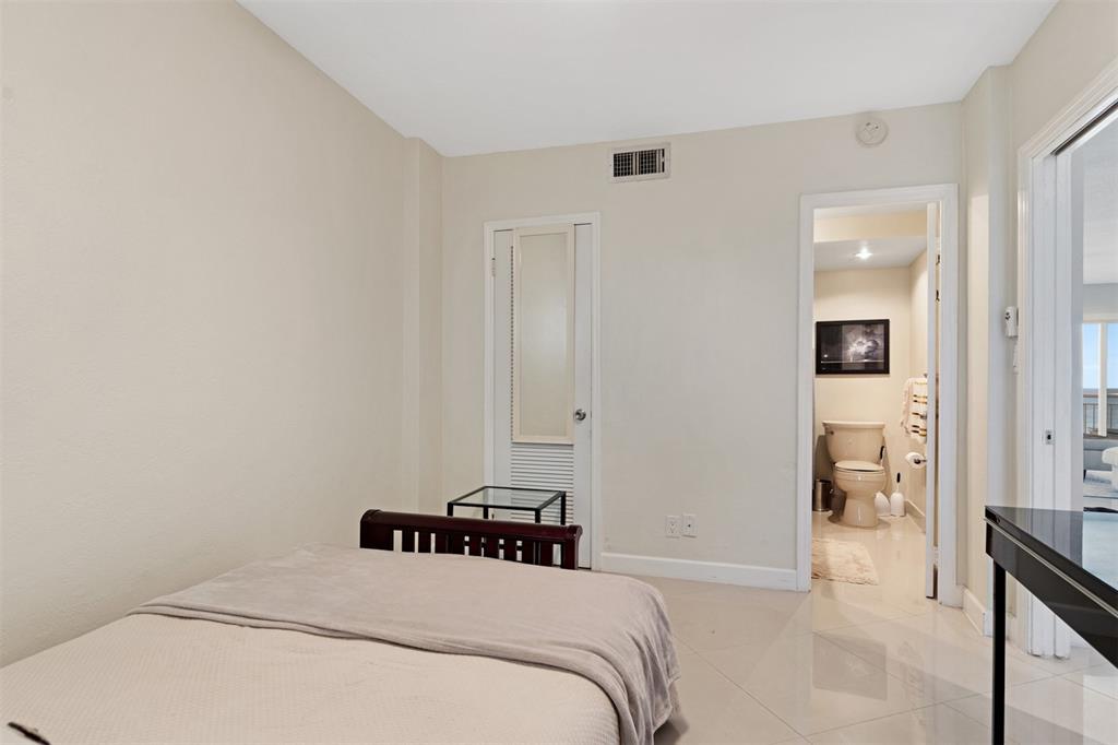 710 North Ocean Boulevard, Unit 806 Pompano Beach, FL 33062 - Photo 14 of 19 a bedroom with a bed and a view of bathroom