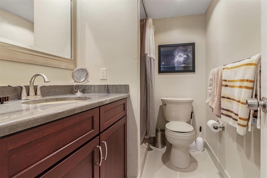 710 North Ocean Boulevard, Unit 806 Pompano Beach, FL 33062 - Photo 15 of 19 a bathroom with a toilet sink and mirror