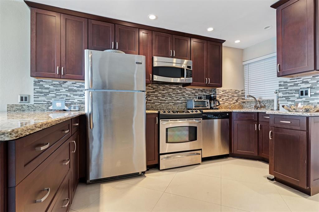 710 North Ocean Boulevard, Unit 806 Pompano Beach, FL 33062 - Photo 6 of 19 a kitchen with stainless steel appliances granite countertop a refrigerator stove a sink and dishwasher