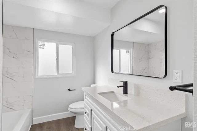 a bathroom with a sink toilet and mirror