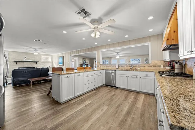 a kitchen with a sink stainless steel appliances and window
