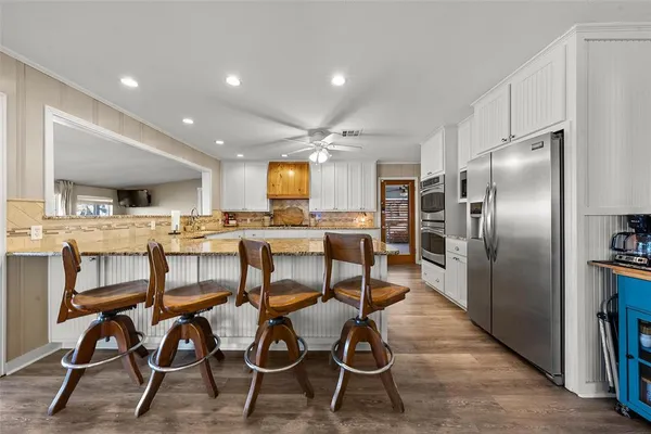 a kitchen with cabinets and chairs