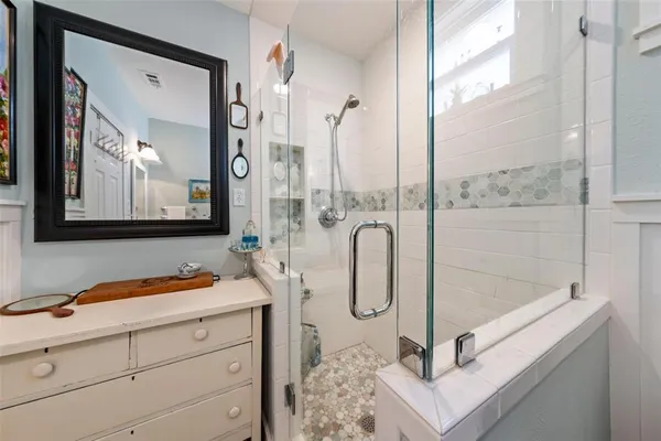 a bathroom with a shower sink and mirror