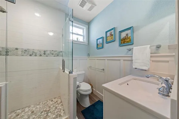 a bathroom with a sink a toilet and shower