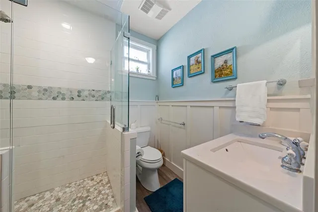 a bathroom with a sink a toilet and shower