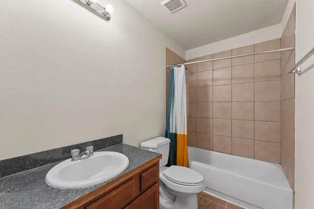 a bathroom with a granite countertop sink toilet a mirror and shower