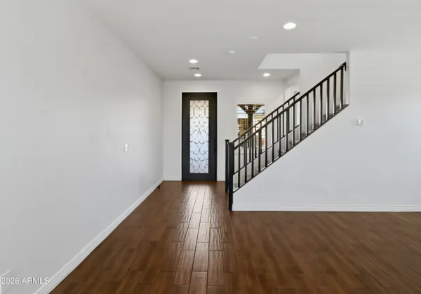 a view of a hallway with wooden floor and staircase