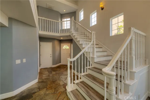 a view of staircase with railing and a chandelier
