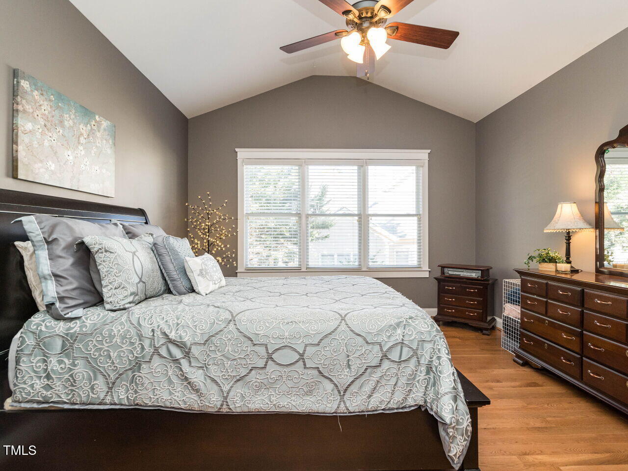 114 Naperville Drive Cary, NC 27519 - Photo 19 of 36 a bedroom with a large bed and a chandelier