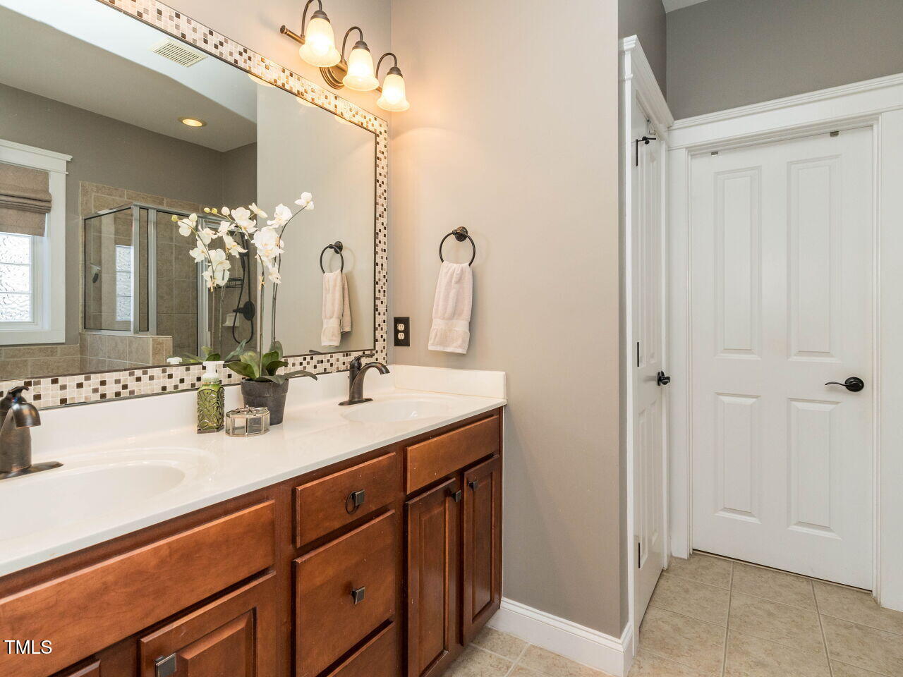 114 Naperville Drive Cary, NC 27519 - Photo 20 of 36 a bathroom with a double vanity sink and a mirror