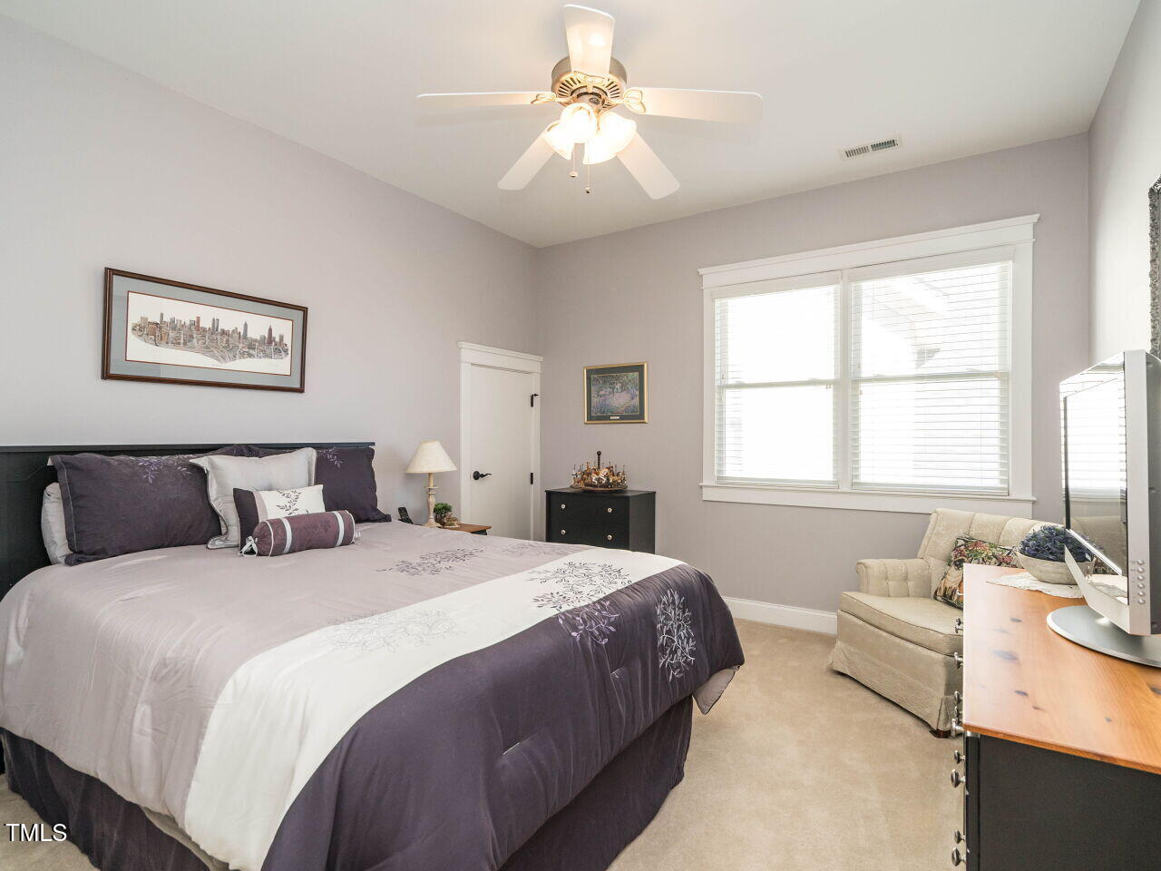 114 Naperville Drive Cary, NC 27519 - Photo 24 of 36 a bedroom with a bed and a chandelier