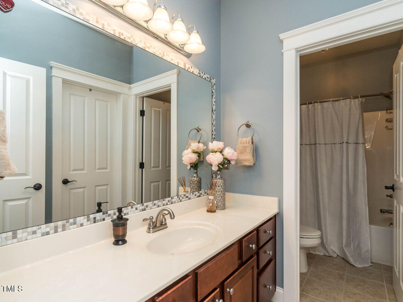 114 Naperville Drive Cary, NC 27519 - Photo 26 of 36 a bathroom with a sink vanity and a mirror