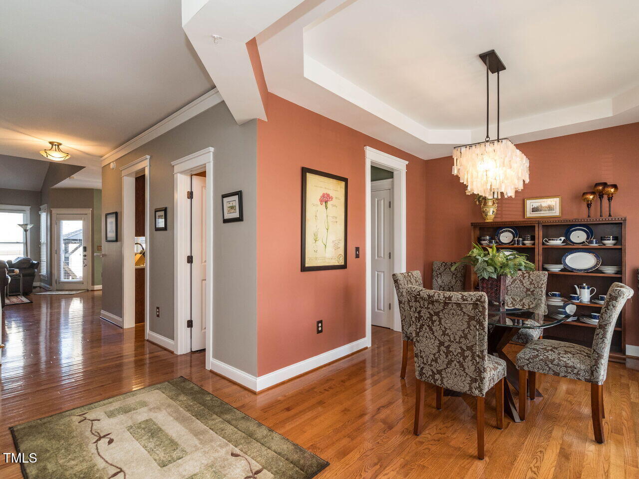 114 Naperville Drive Cary, NC 27519 - Photo 6 of 36 a dining room with wooden floor a chandelier a glass table and chairs