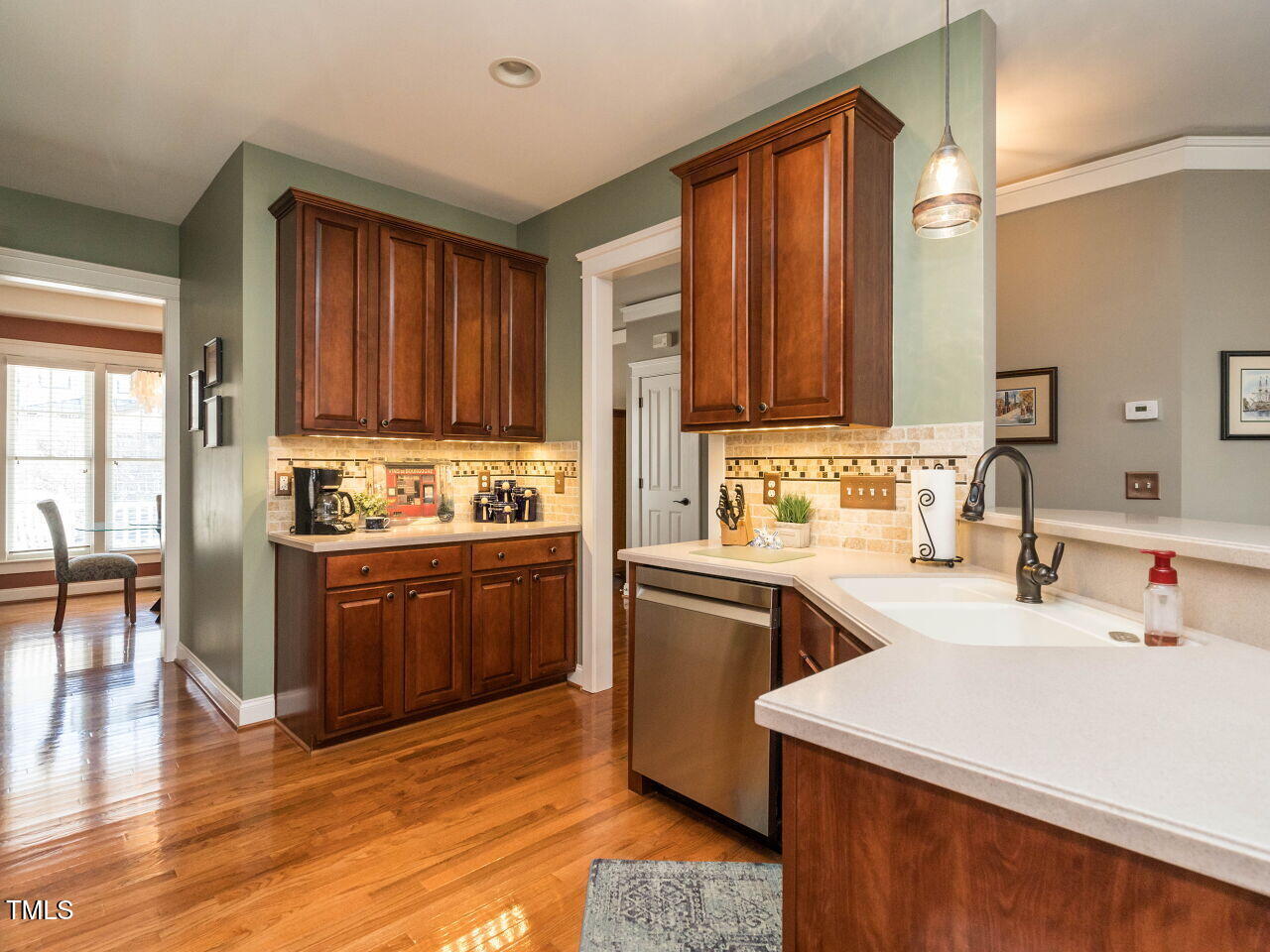 114 Naperville Drive Cary, NC 27519 - Photo 10 of 36 a kitchen with stainless steel appliances granite countertop a sink dishwasher stove and wooden cabinets with wooden floor