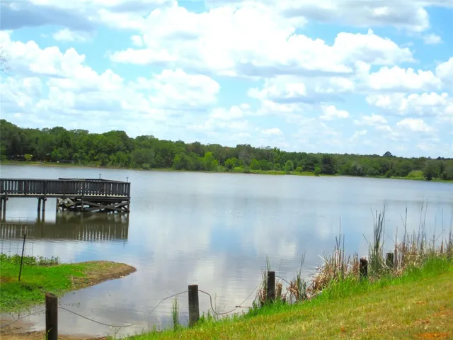 an aerial view of residential house with outdoor space and trees all around