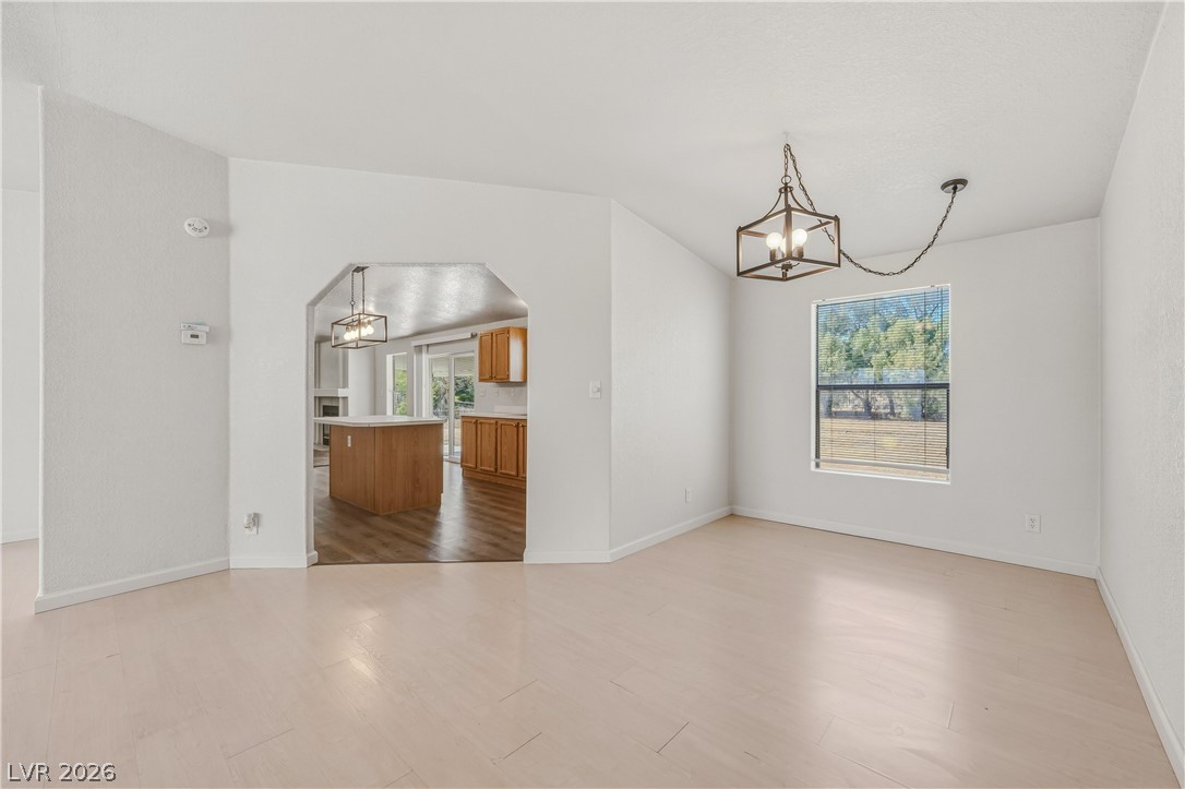 1890 West Dyer Road Pahrump, NV 89048 - Photo 6 of 40 Bright interior space features light flooring, an arched doorway, and an open layout connecting to the kitchen.